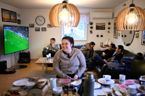 A giant flat screen in Olsen's house shows a football match from England's Premier League