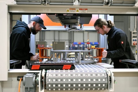 Employees work at a machine at the German firm 4JET