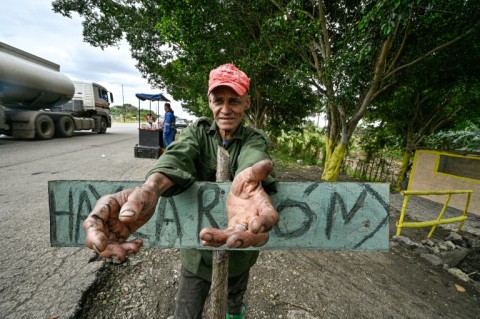 Cuban vendor Elio Galvan sells charcoal to families who have begun cooking over open fires amid ever longer blackouts caused by fuel shortages