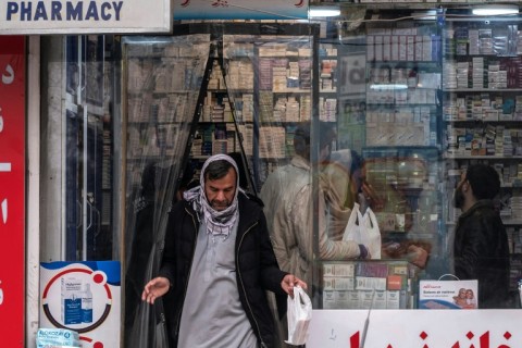 A man leaves a pharmacy in Kabul after buying medicine