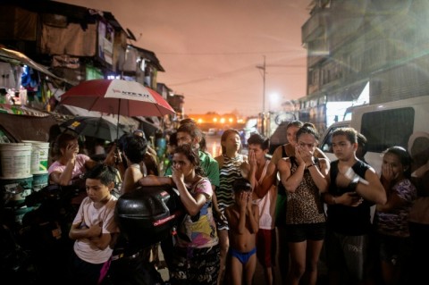 Residents near a crime scene on September 28, 2016 where three alleged drug dealer were killed after a drug raid in a shanty community in Manila