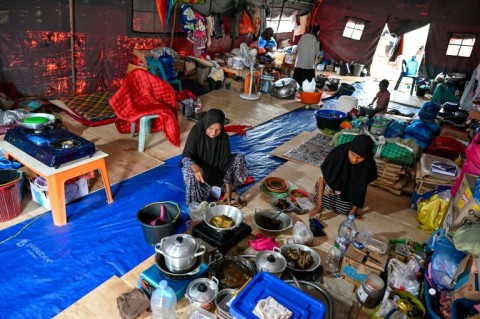 Displaced Indonesians cook meals to break their Ramadan fast in a tent in Pidie Jaya