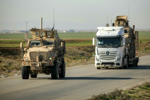 A truck loaded with a US armoured vehicle