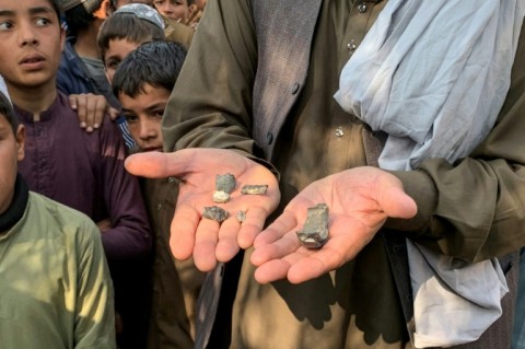 An Afghan man shows mortar shell remains in the Ghani Khel district of Nangarhar province on March 1, 2026 amid ongoing cross-border fighting between Afghanistan and Pakistan.