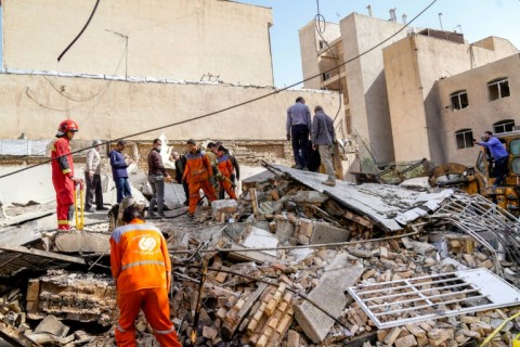 In this picture obtained from Iran's ISNA news agency, rescuers search through the rubble of a collapsed building at the site of a strike in Tehran