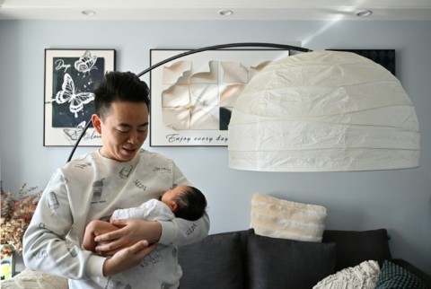 Zhu Yunfei holds his newborn baby Zhu Wanning in Langfang, northern China's Hebei province