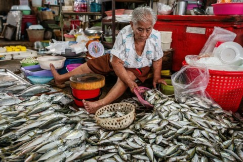 Vendor Sopa Chaiyakul prepares fish for sale at a fresh market in Sriracha