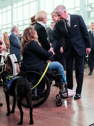 King Philippe shakes hands with Beatrice de Lavalette, who became a Paralympic horse rider after losing her legs in the bombings