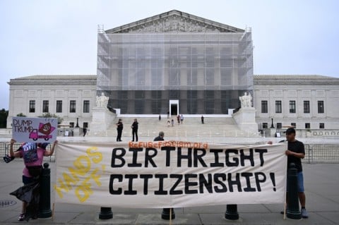 Demonstrators hold a banner outside the US Supreme Court during a June 27, 2025 protest