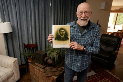 Bill McFarland holds up a photo of his great-grandfather, William DeLyle Frisbee, who left his family a cache of old silent movies