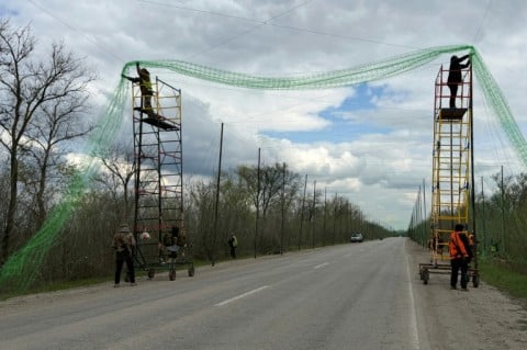 Ukrainian servicemen cover the road with a net to protect vehicles from drone attacks in the Zaporizhzhia region