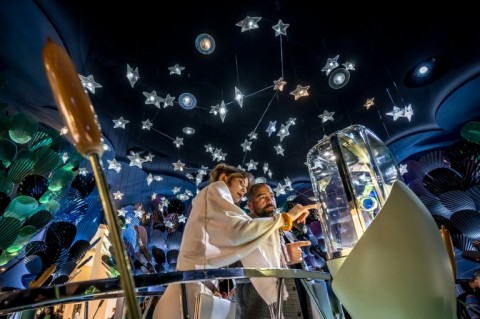 Visitors looking at watches on display at the booth of Van Cleef & Arpels