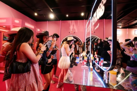 People test products inside the promotional booth of South Korean skincare brand Medicube