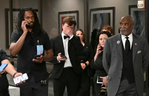 Attendees check their phones in the lobby of the Washington Hilton after shots were heard