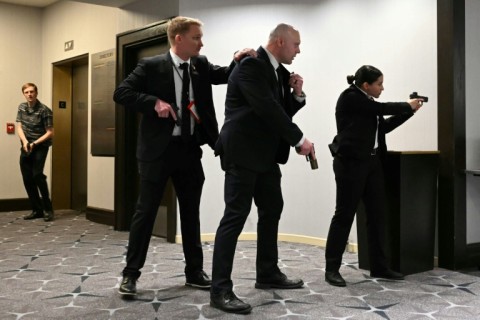 Agents draw their guns after loud bangs were heard during the White House Correspondents' dinner