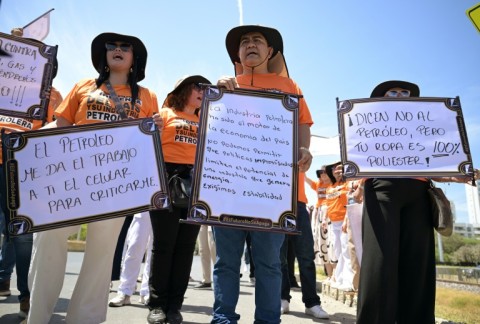 Demonstrators hold signs supporting the oil industry outside the international conference on transitioning away from fossil fuels, in Santa Marta, Colombia
