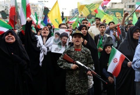 A young enthusiast dressed in military attire holds a mock rifle during a rally to show solidarity and support to the new Iranian supreme leader Ayatollah Mojataba Khamenei in Tehran