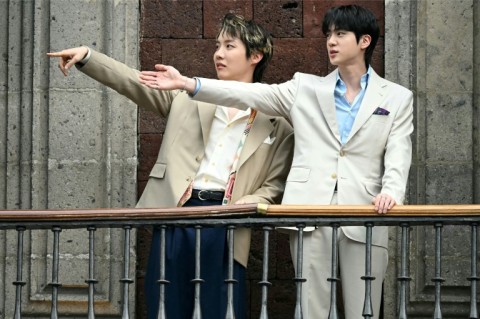 J-Hope (L) and Jin (R), from the South Korean K-pop band BTS, acknowledge fans from the balcony of the National Palace in Mexico City
