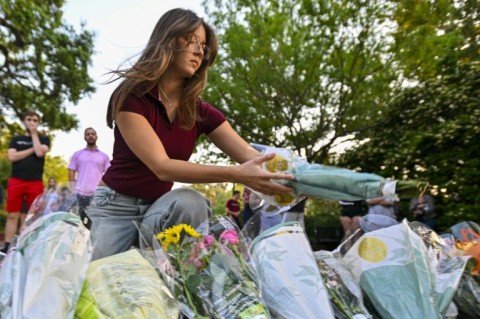A woman places flowers at a vigil near the scene of a deadly shooting at Florida State University in 2025, when the suspect was believed to have consulted AI chatbot ChatGPT before the attack