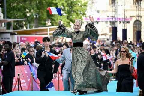 Monroe Vata Rigby, aka Monroe and representing France with the song 'Regarde !', poses for photographers on the turquoise carpet for the opening ceremony of the Eurovision Song Contest 2026 at the City Hall Square in Vienna, Austria