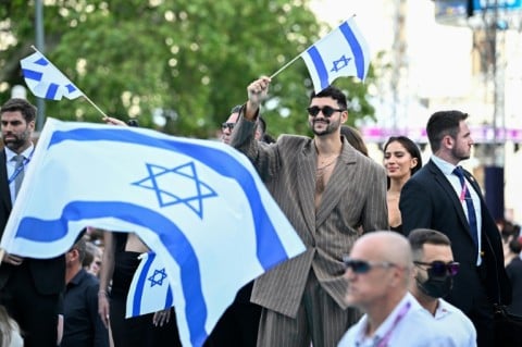 Israeli singer Noam Bettan, representing Israel with the song 'Michelle', surrounded by security, poses for photographers on the turquoise carpet for the opening ceremony of the Eurovision Song Contest 2026