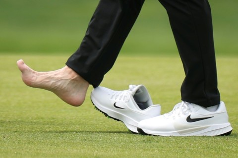 Second-ranked Rory McIlroy, the reigning Masters champion, tends to his foot on the 18th hole during a practice round ahead of the 108th PGA Championship at Aronimink