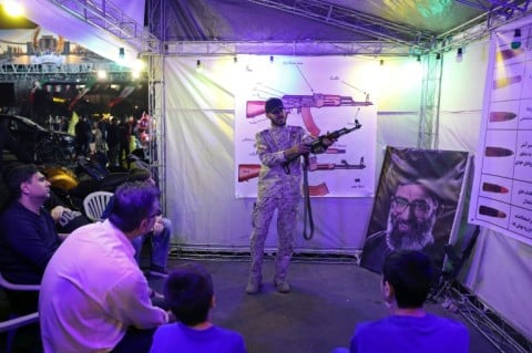 Iranian military personnel educate people how to use a gun in Tehran