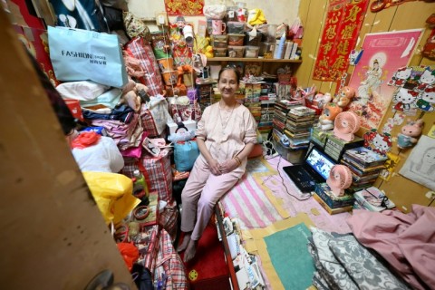 Lisa Lau, 48, sits on her bed in her subdivided housing unit in Kowloon, Hong Kong