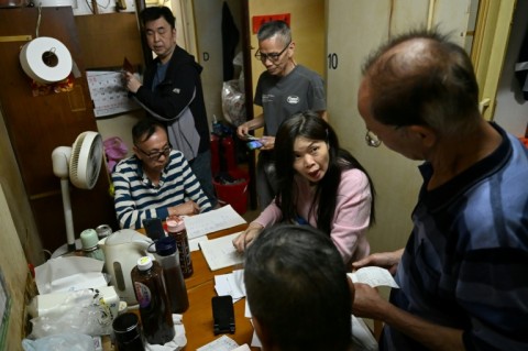Social worker Sze Lai-shan (2nd R), deputy director of the Society for Community Organistion (SOCO) -- an NGO that works with underprivileged groups -- speaks to residents in a subdivided housing unit in Kowloon, Hong Kong
