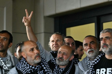 Members of a Gaza-bound flotilla pose outside a terminal following their arrival at Istanbul airport