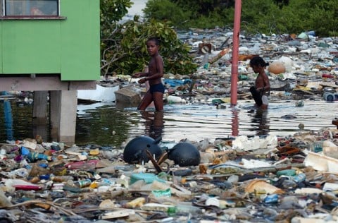 Children wade through floating garbage as a king tides inundates Funafuti Atoll in Tuvalu.