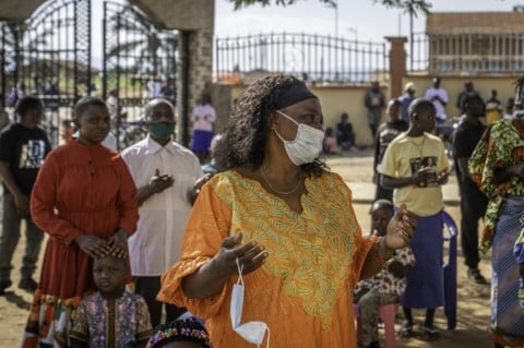 A Catholic prays while wearing a mask following local authorities’ instructions to limit Ebola's spread
