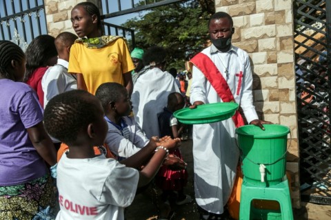 Parishioners wash their hands before entering church as their region battles an Ebola outbreak which has killed more than 200 people