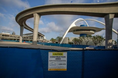 A closed construction area is seen near The SkyLink Automated People Mover line and the Theme Building and Air Traffic Control Tower at Los Angeles International Airport