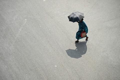 A pedestrian carries an umbrella on a hot day in Chennai