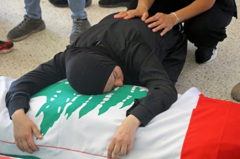A mourner weeps over the body of a victim killed in a strike, before a funeral in Tyre, southern Lebanon on May 28