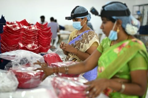 Workers wear GoPro cameras on their heads recording actions through motion capture inside a factory in Tamil Nadu's Karur district