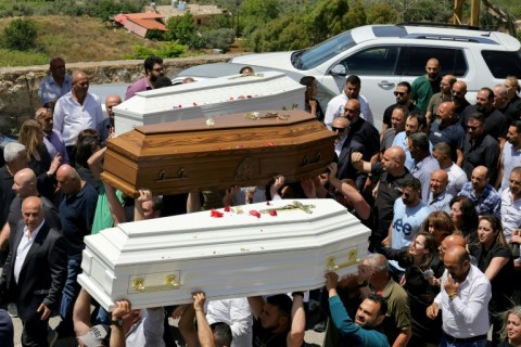 Relatives and friends of a man who was killed along with his son and daughter in an Israeli strike in southern Lebanon attend their funeral in the Christian border village of Qlayaa on June 3, 2026