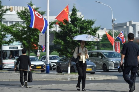 The national flags of North Korea and China displayed on a street in Pyongyang as Xi Jinping visits