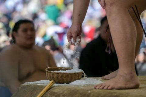 During the bouts, the wrestlers, known as rikishi, compete on a clay surface covered with a thin layer of salt, which is swept from time to time by the yobidashi (announcers)