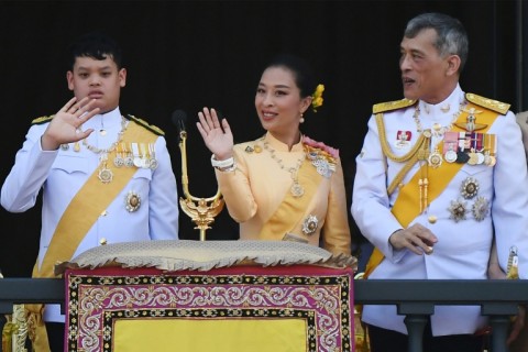 Thailand's Prince Dipangkorn Rasmijoti (L), Princess Bajrakitiyabha Mahidol (C) and King Maha Vajiralongkorn (R) wave from the balcony of Suddhaisavarya Prasad Hall of the Grand Palace in 2019