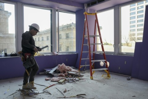 A worker walks through the construction site of 77 Water Street, a former office building being transformed into luxury rental apartments