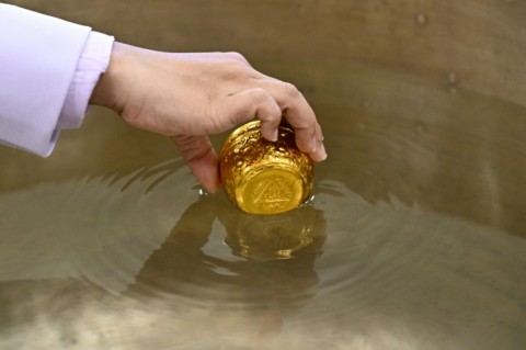 An official dips a cup while paying respects in front of a portrait of the late Thai Princess Bajrakitiyabha Mahidol in the royal throne hall at the Grand Palace in Bangkok on June 13, 2026.