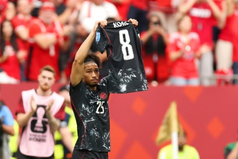 Nathan Saliba holds up injured team-mate Ismael Kone's shirt after scoring Canada's fourth goal in a 6-0 rout of Qatar
