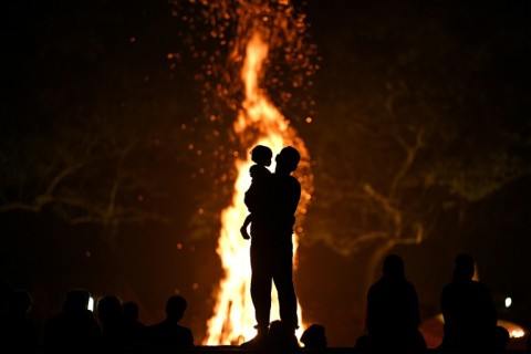 A father and child before a bonfire at Auroville