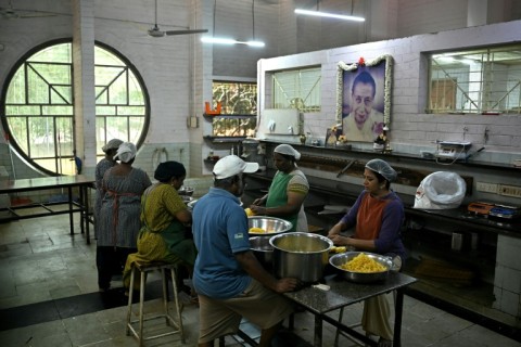 Shared life: preparing food in Auroville's solar-powered kitchen, watched over by a pictures of 'The Mother'