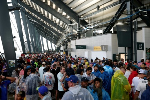 Soaked French and Iraqi fans used the two-hour delay to dry off