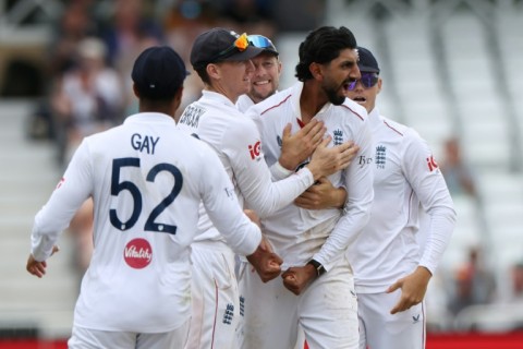 England off-spinner Shoaib Bashir (2R) celebrates with teammates after trapping New Zealand's Rachin Ravindra lbw in the third Test at Trent Bridge