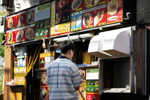 A man orders from a kebab shop in Tokyo's Okubo–Shin area, an area known for its large immigrant communities