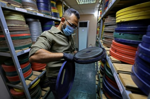 Producer Haider Ibrahim inspects a film reel at the National Centre for Archives and Iraqi Memory in Baghdad